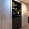 Elegant hallway storage unit with plants and decorative items.