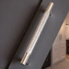 Textured metallic wall light in modern interior setting.