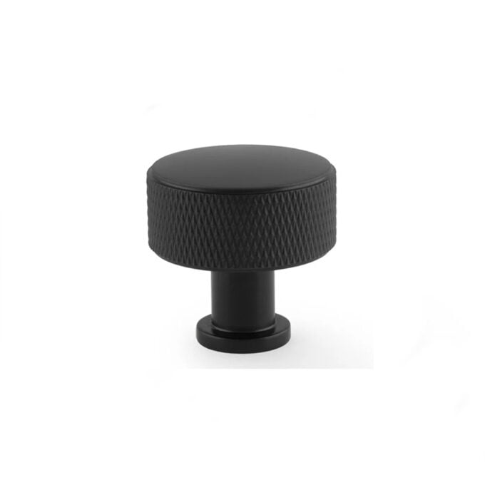 Black textured round knob on white background.