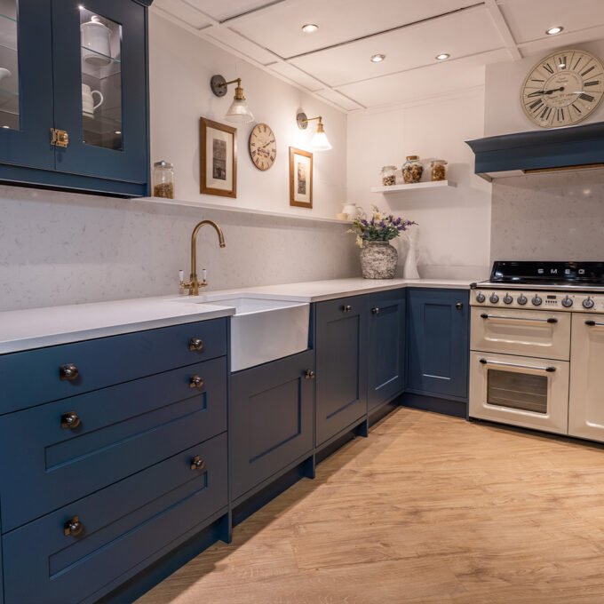 Elegant blue kitchen with gold fixtures and marble countertops.