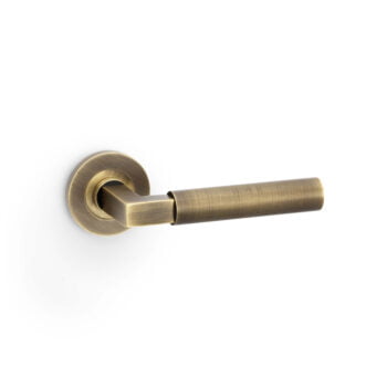 Antique brass door lever on white background.