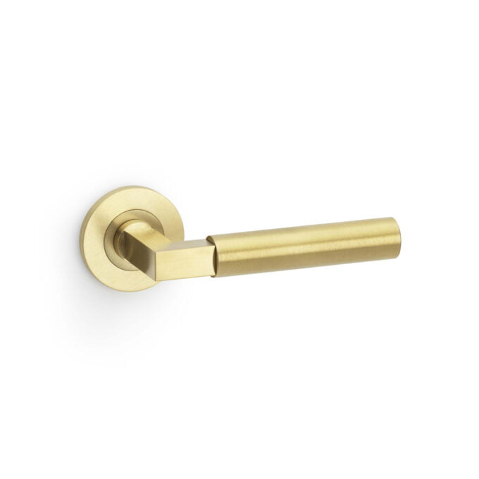 Gold-coloured modern lever door handle on white background.