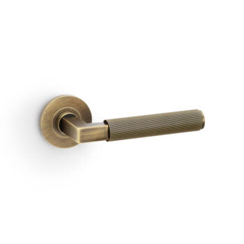 Brass textured door lever on white background