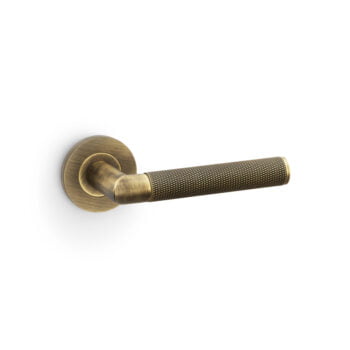 Antique brass door lever on white background.