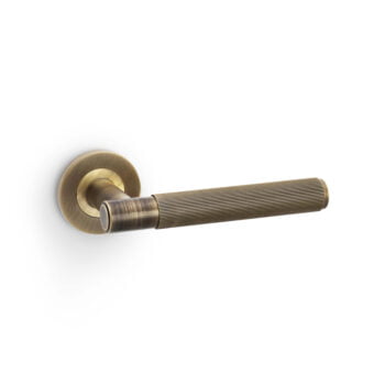 Brass door handle with grooved grip on white background.