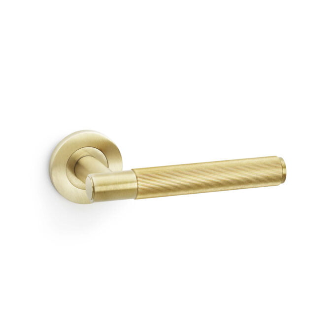 Gold, ridged handle door lever on white background.