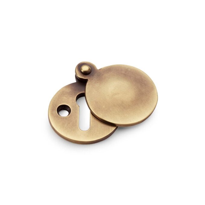 Brass disk keyhole cover on white background.