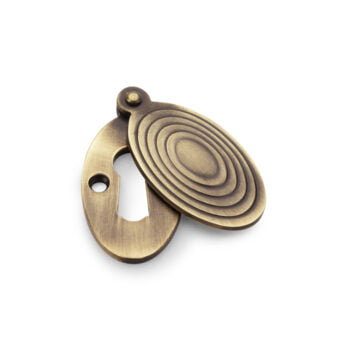 Antique bronze bottle opener with circular design.