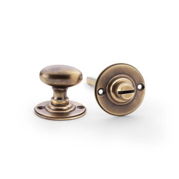 Antique brass door knob and keyhole on white background.