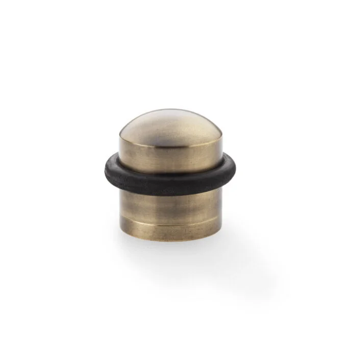 Antique brass doorstop on white background.