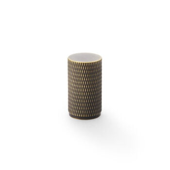 Patterned cylindrical wooden container on white backdrop.