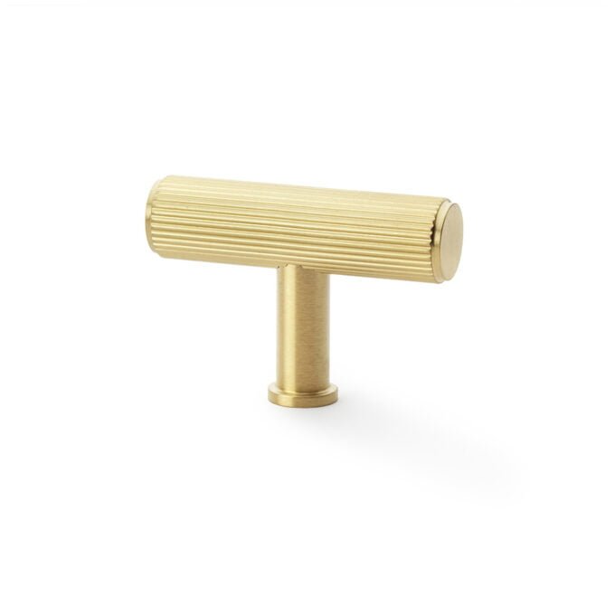 Gold-coloured ridged cabinet handle on white background.