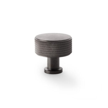 Textured black metal cabinet knob on white background