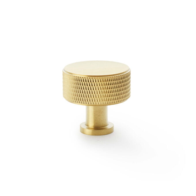 Gold textured cabinet knob on white background.