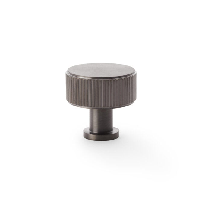 Metallic ribbed cabinet knob on white background.