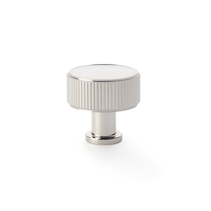 Silver grooved cabinet knob on white background.