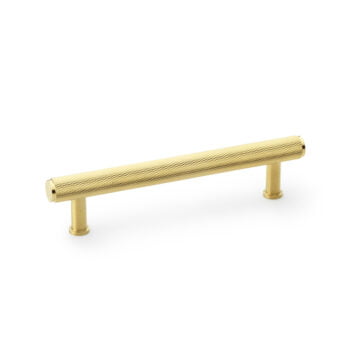 Gold-coloured textured cabinet handle on white background.