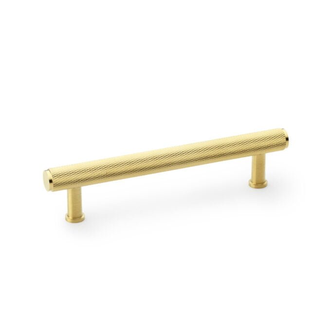 Gold-coloured textured cabinet handle on white background.