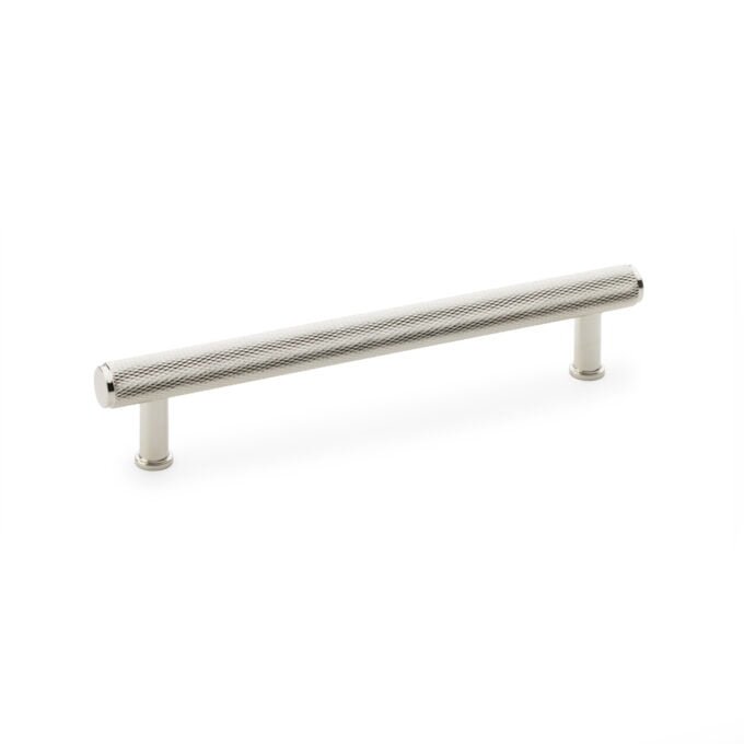 Knurled silver cabinet handle isolated on white background.