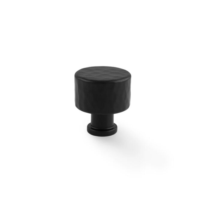 Black round cabinet knob on white background.