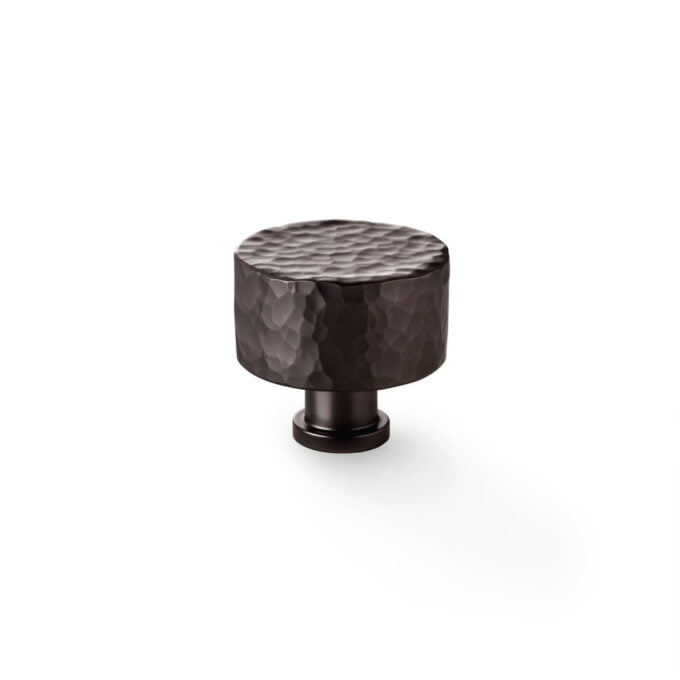 Hammered bronze cabinet knob on white background.