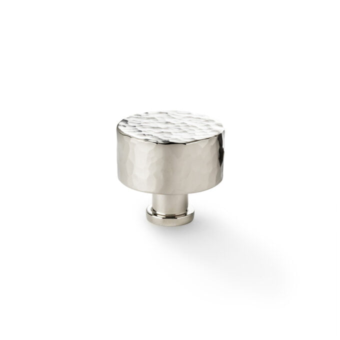 Silver hammered cabinet knob on white background.