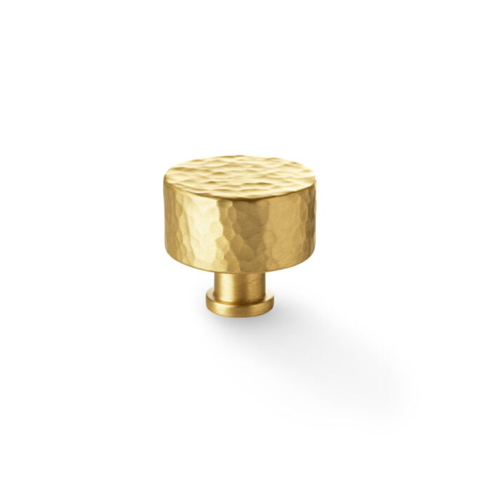 Textured gold cabinet knob on white background