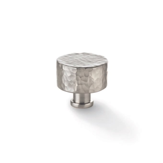 Hammered metal cabinet knob on white background