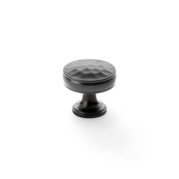 Black decorative cabinet knob on white background.