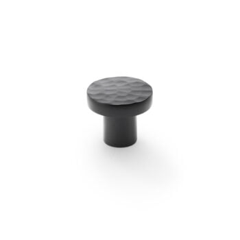 Textured black cabinet knob on white background.
