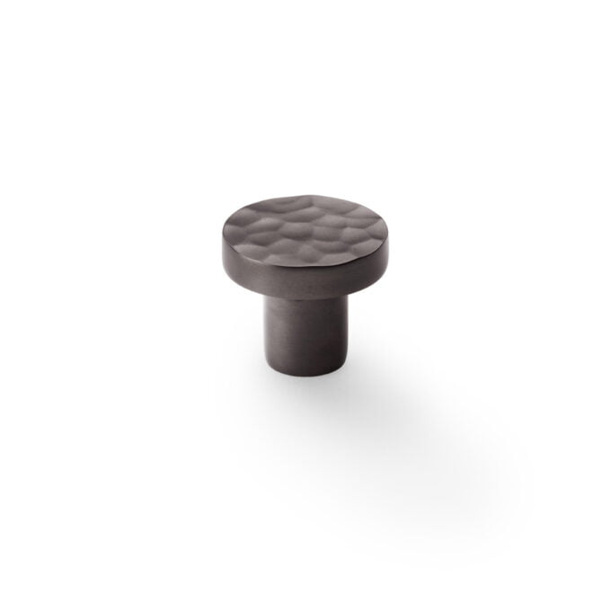 Textured black cabinet knob on white background.