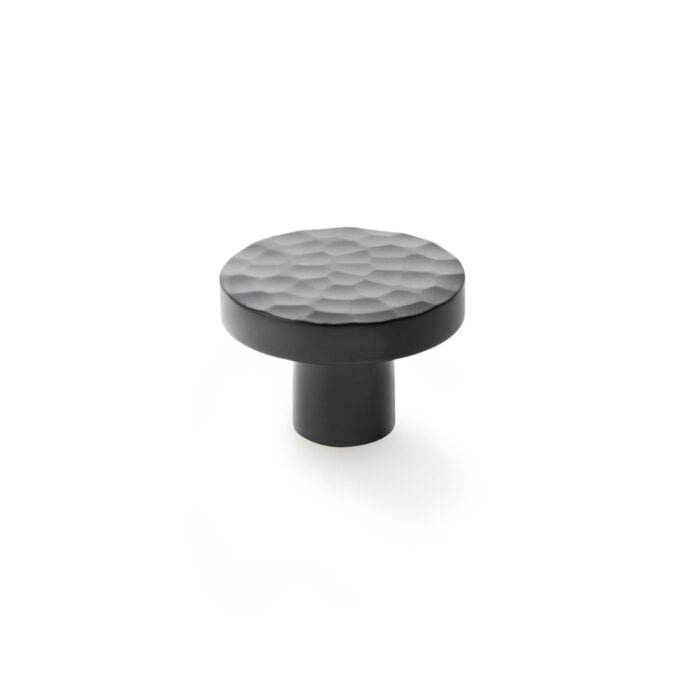 Black textured modern cabinet knob on white background.