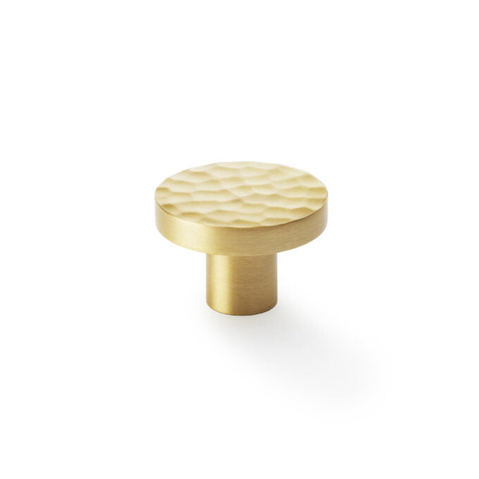 Textured gold cabinet knob on white background