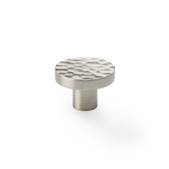 Textured stainless steel cabinet knob on white background.