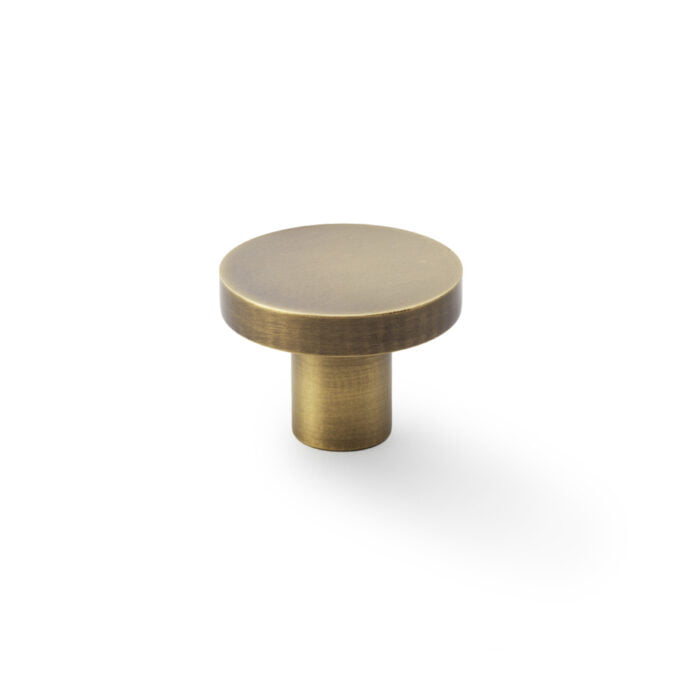 Brass cabinet knob on white background.