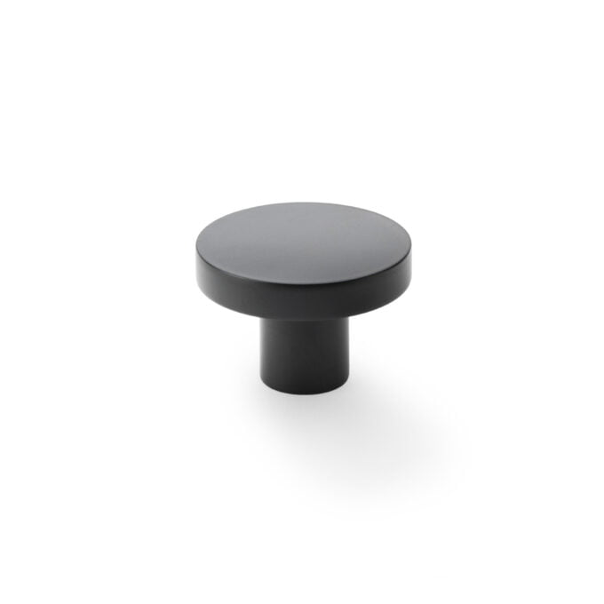 Modern black cabinet knob on white background.