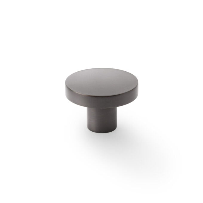 Matte grey cabinet knob on white background.