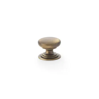 Antique brass cabinet knob on white background.