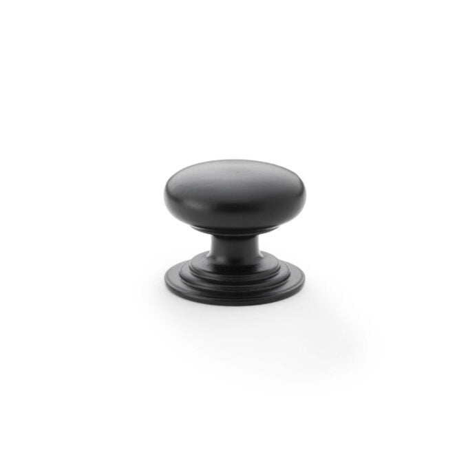 Black cabinet knob on white background.