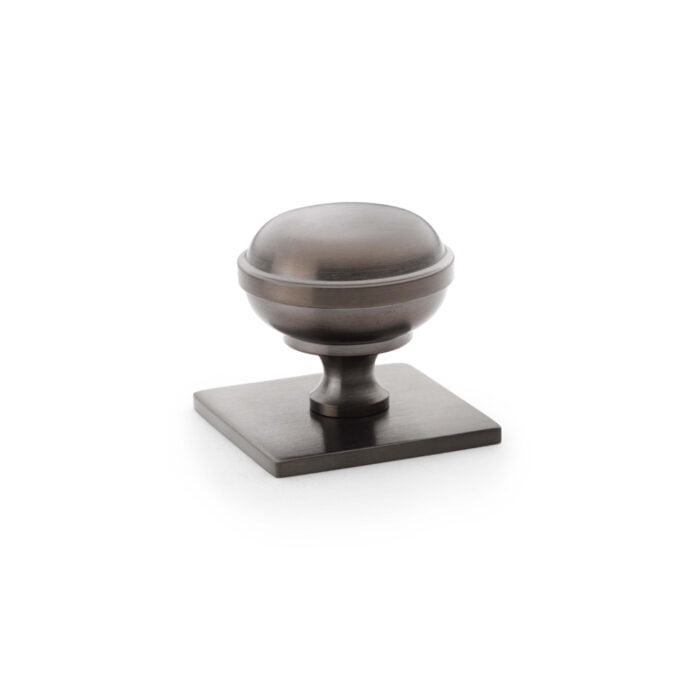 Antique-style bronze cabinet knob on white background.