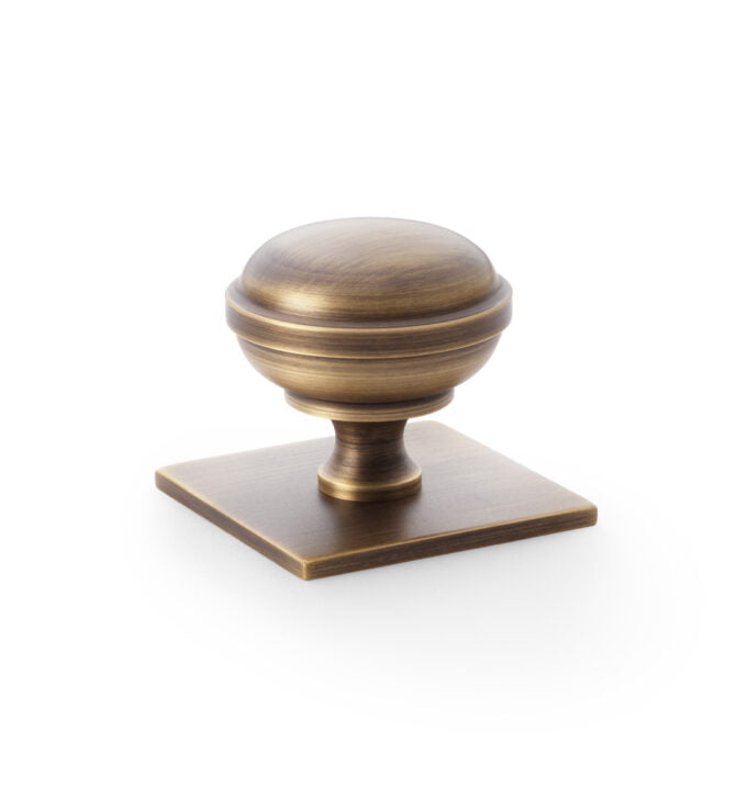 Antique bronze cabinet knob on white background.