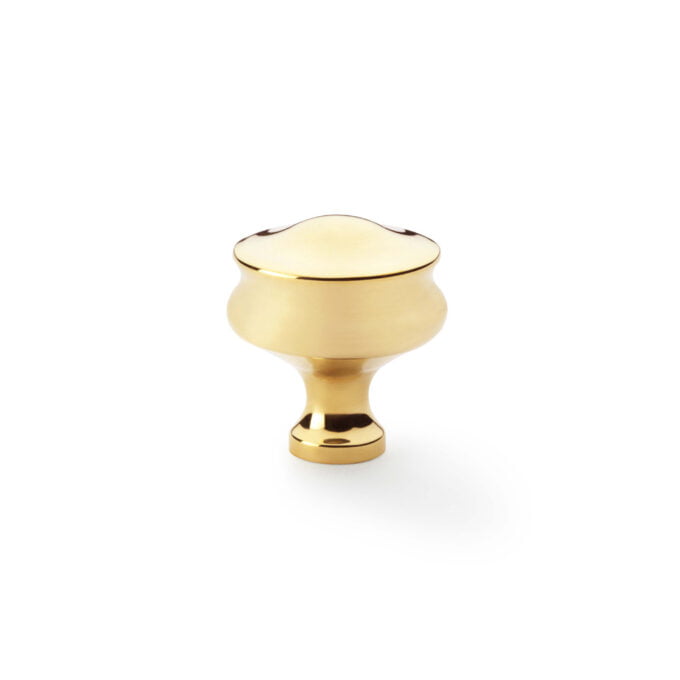 Gold cabinet knob on white background.