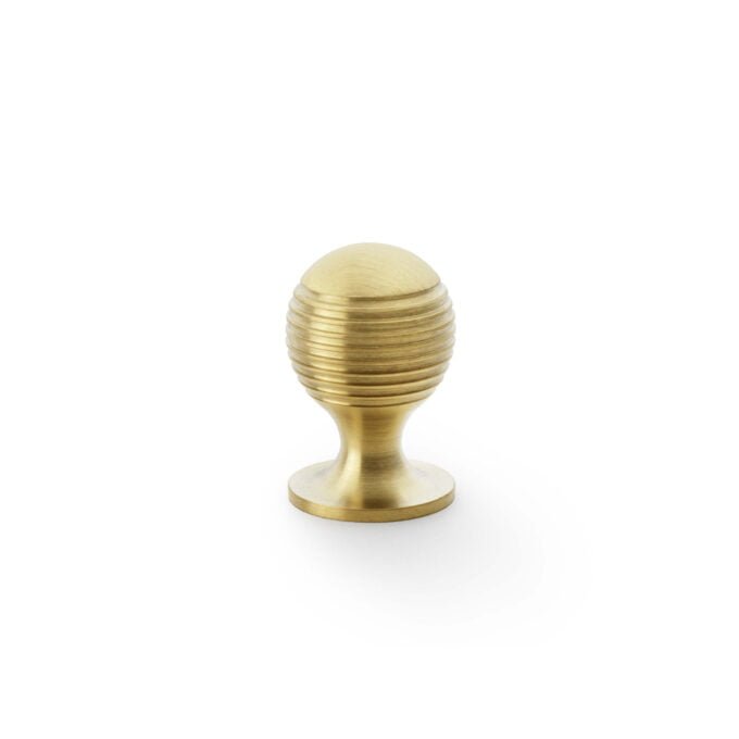 Gold egg-shaped cupboard door handle on white background.