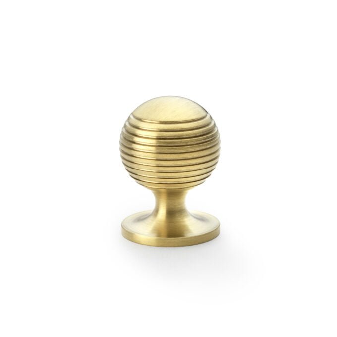 Brass cupboard door knob with ridged spherical design.