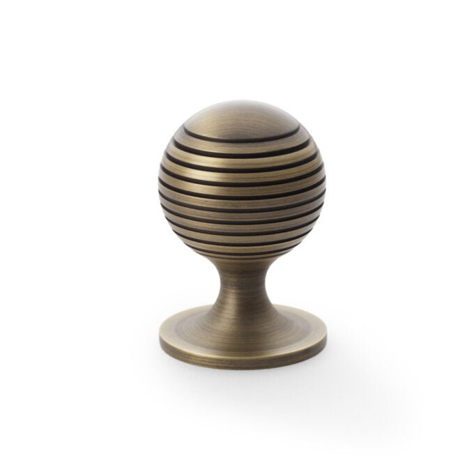 Striped bronze cabinet door handle on white background.