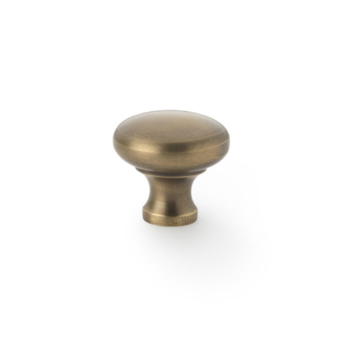 Antique brass cabinet knob on white background.