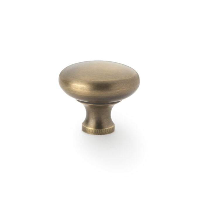 Antique brass cabinet knob on white background.