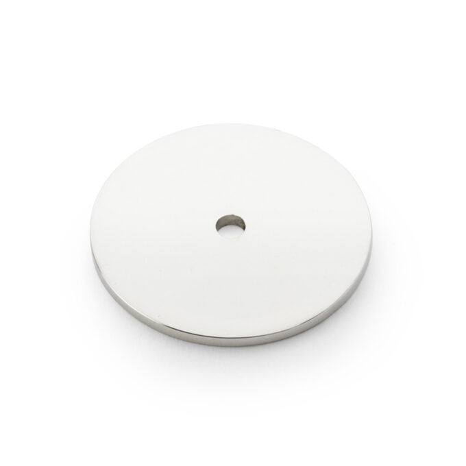 White metal disc with central hole on white background.