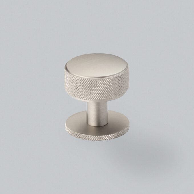 Brushed silver cabinet knob on grey background