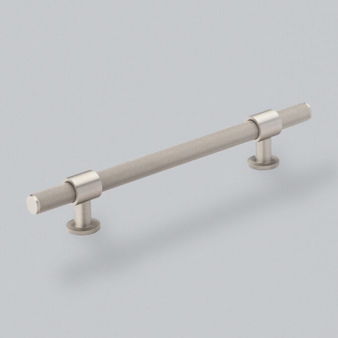 Brushed Nickel knurled cabinet handle on grey background